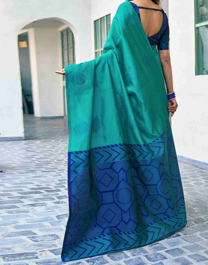 Back view of model in teal green soft silk saree showing navy blue chevron zari border and open back navy blouse