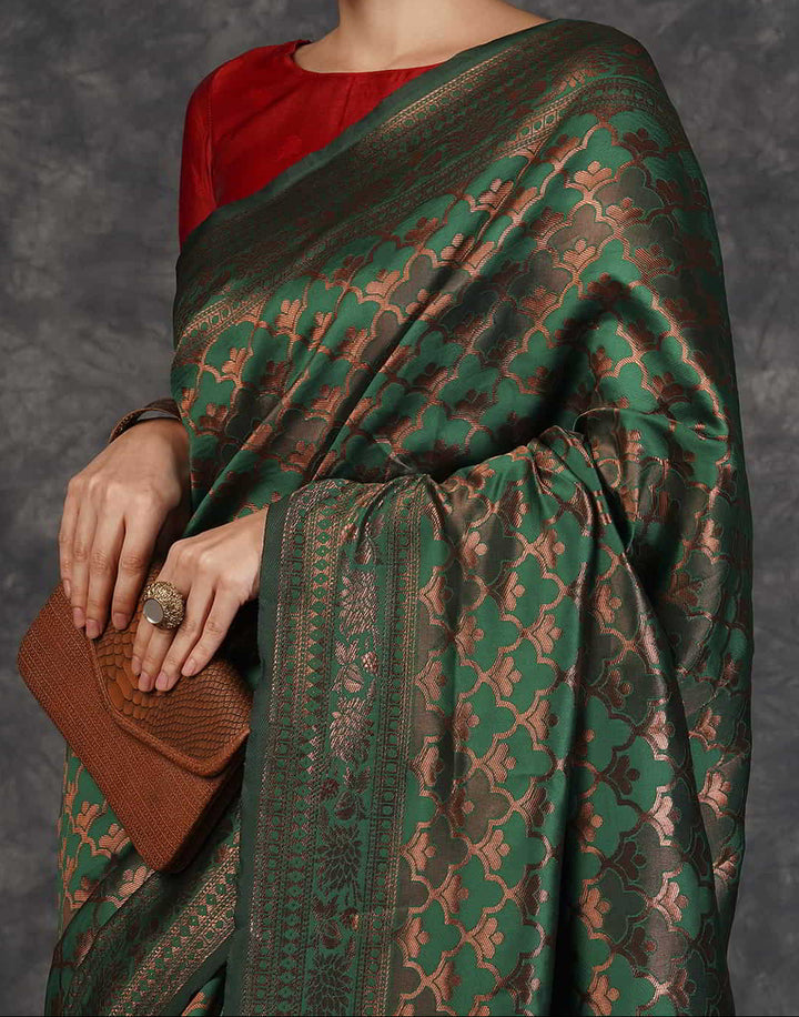 Flat lay close-up of forest green Banarasi silk saree body showing all-over copper zari ogee shell jaal weave and red border