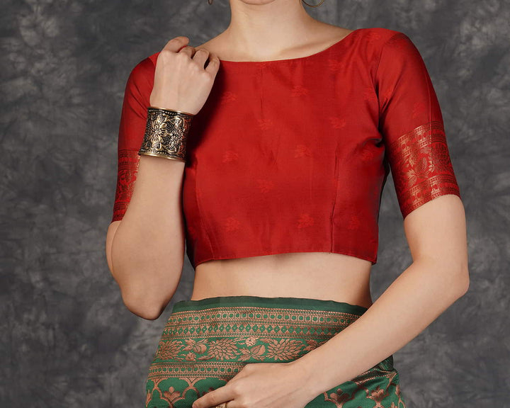 Flat lay close-up of red contrast pallu showing dense all-over copper zari chakra and floral jaal weave with tassel fringe