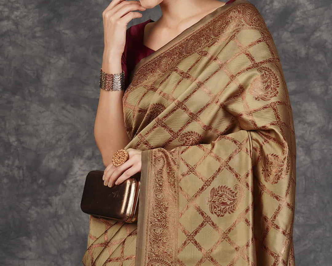 Back view of model in golden beige Banarasi silk saree showing open back maroon blouse with tassel tie and grand maroon pallu