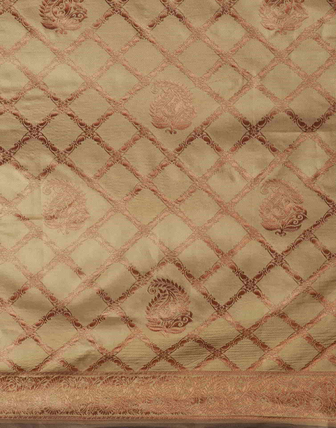 Flat lay close-up of maroon pallu showing large copper zari floral tree buttas and tassel fringe