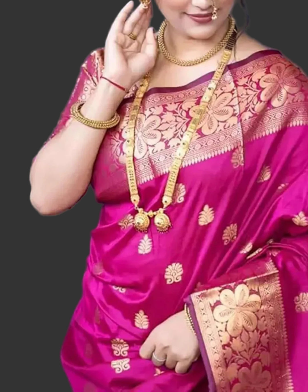 Close-up portrait of model in rani pink Banarasi silk saree with gold zari buttas and long gold haar