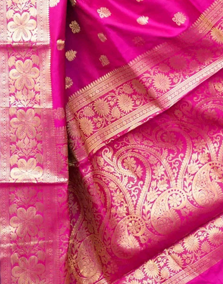Flat lay close-up of rani pink Banarasi silk saree showing gold zari paisley jaal pallu and floral border