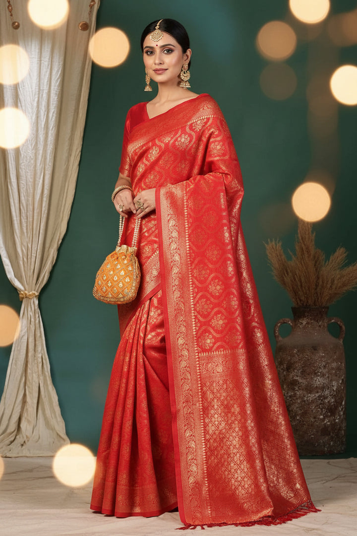 Front view of model in red Banarasi silk saree with gold zari ogee jaal and pearl potli bag