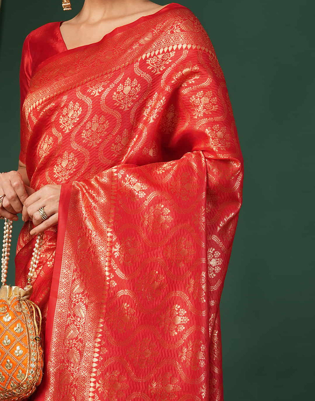 Flat lay close-up of red Banarasi silk saree body showing all-over gold zari ogee jaal with floral bouquet motifs