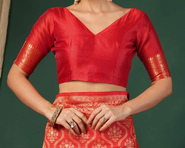 Flat lay close-up of red Banarasi silk saree pallu showing dense gold zari diamond lattice weave and tassel fringe