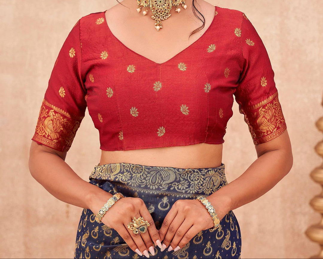 Full front view of model in navy blue Banarasi shimmer silk saree with red blouse and gold jewellery in candlelit setting