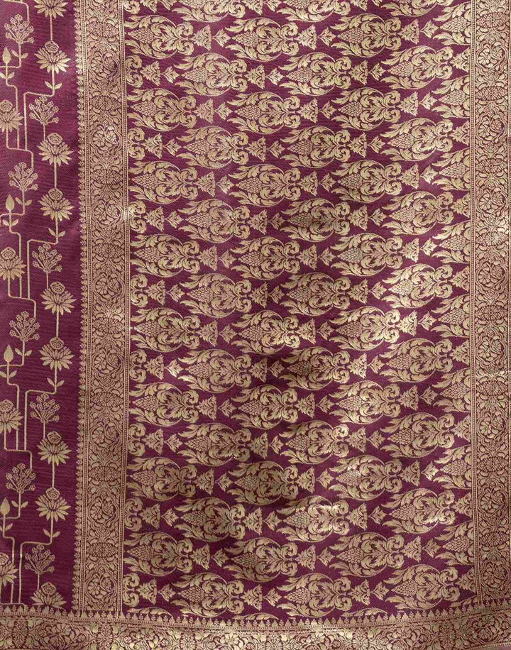 Three-quarter view of model in wine purple Banarasi silk saree with gold chandelier jhumkas and gold bangles