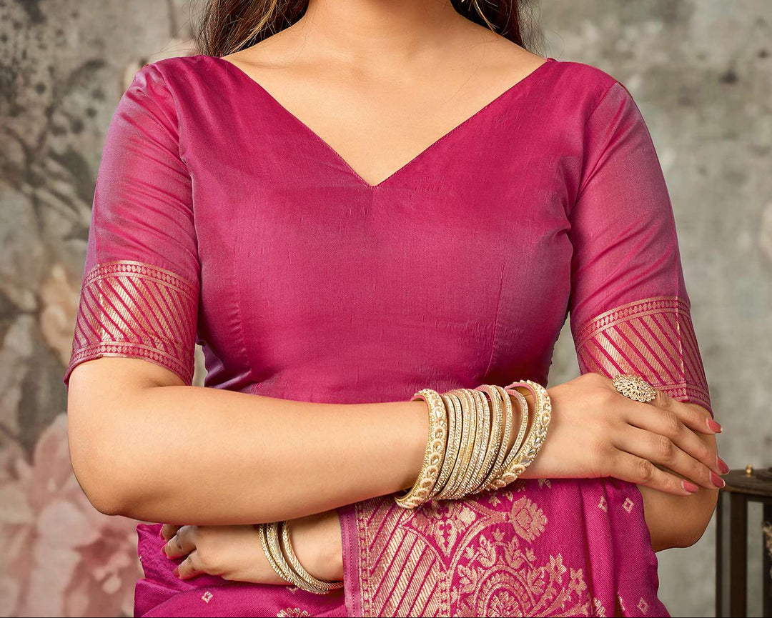 Three-quarter view of model in magenta Banarasi silk saree with gold bangles and jhumkas