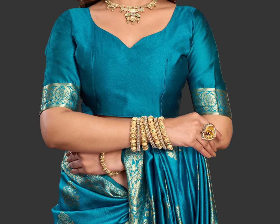 Full front view of model in cerulean blue Banarasi silk saree with large gold zari oval buttas and gold necklace