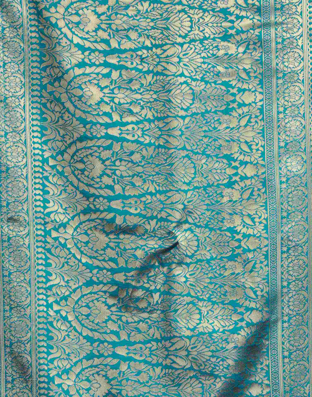 Three-quarter view of model in cerulean blue Banarasi silk saree showing gold zari border and pallu drape