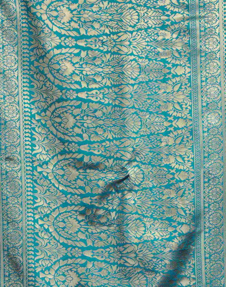 Three-quarter view of model in cerulean blue Banarasi silk saree showing gold zari border and pallu drape