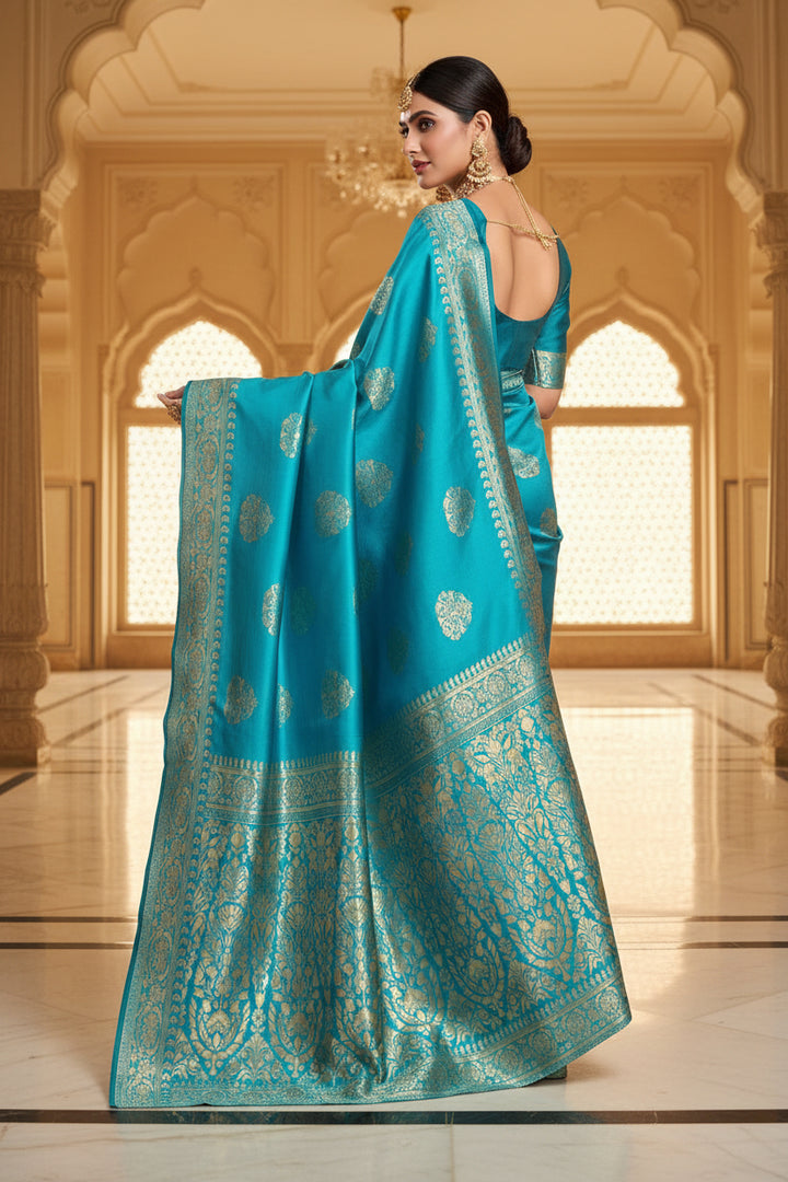 Full front view of model in cerulean blue Banarasi silk saree with gold bangles and polki jewellery