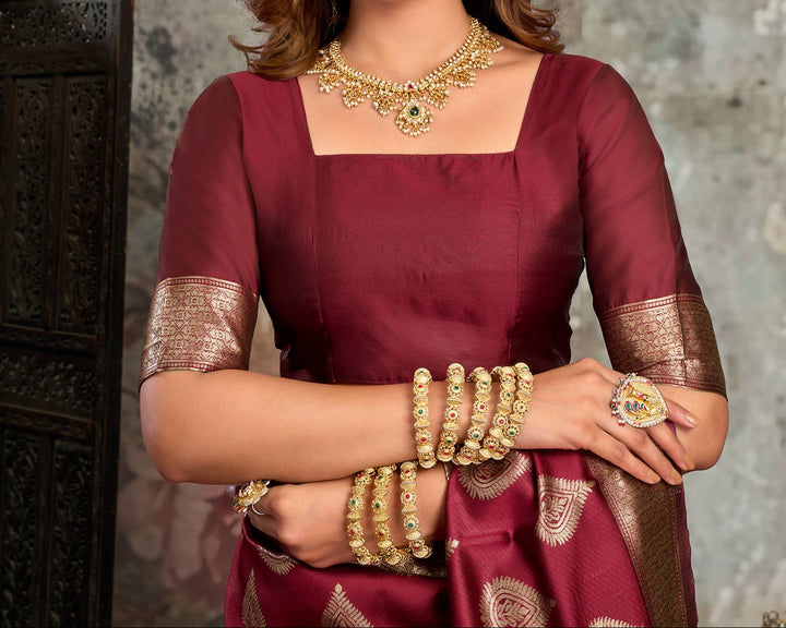 Back view of model in maroon Banarasi silk saree showing large gold zari mango buttas and dense antique gold jaal pallu