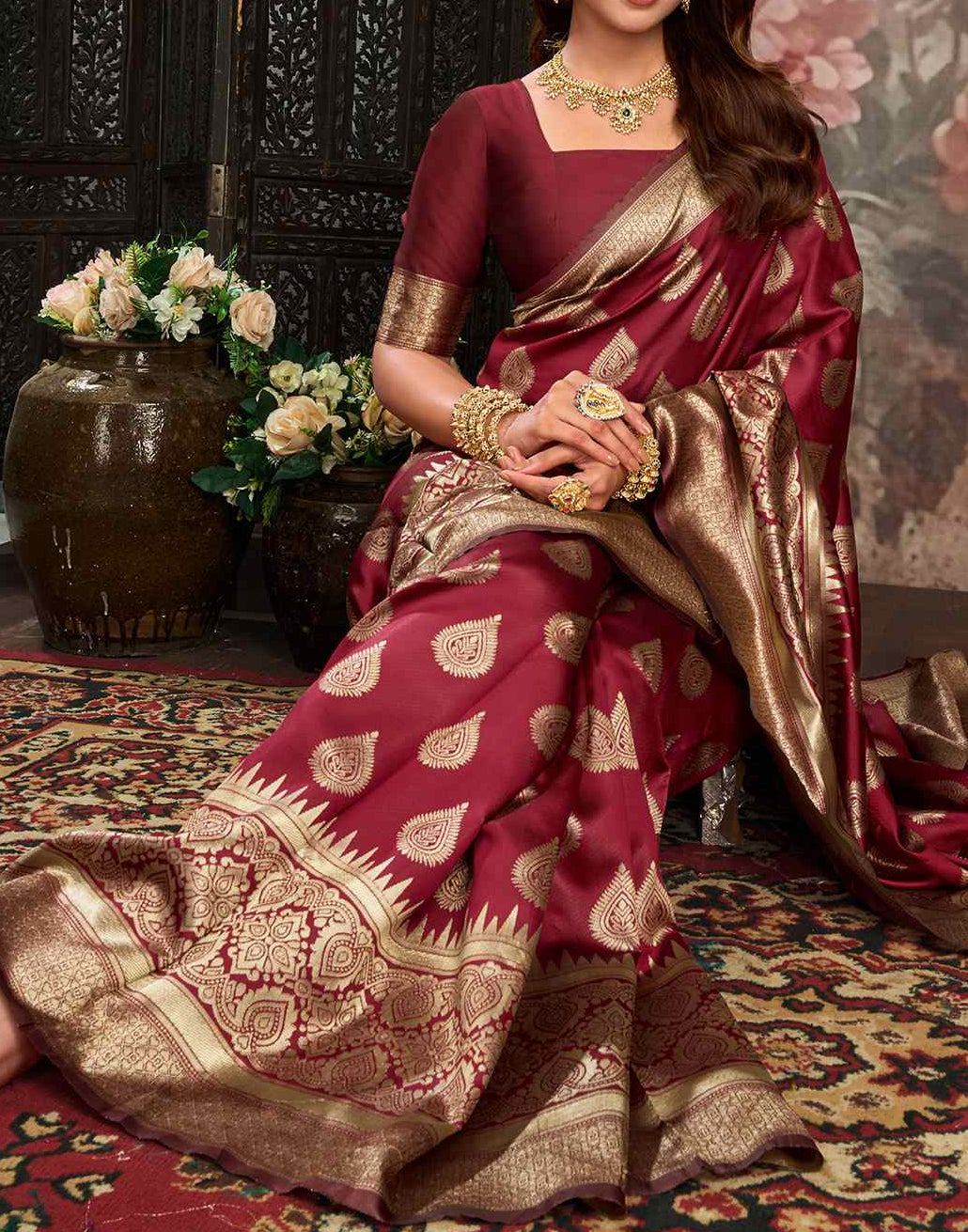 Three-quarter portrait of model in maroon Banarasi silk saree showing antique gold jaal pallu drape and gold jewellery