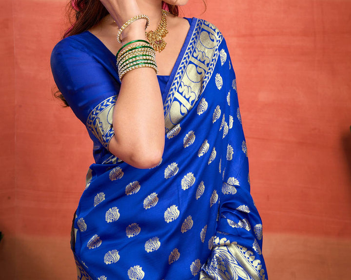Seated close-up of model in royal blue Banarasi silk saree showing gold zari shell buttas and antique gold border detail