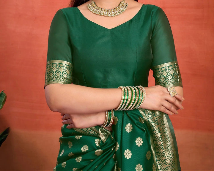 Flat lay close-up of bottle green Banarasi silk saree body showing all-over gold and silver zari ogee shell jaal weave