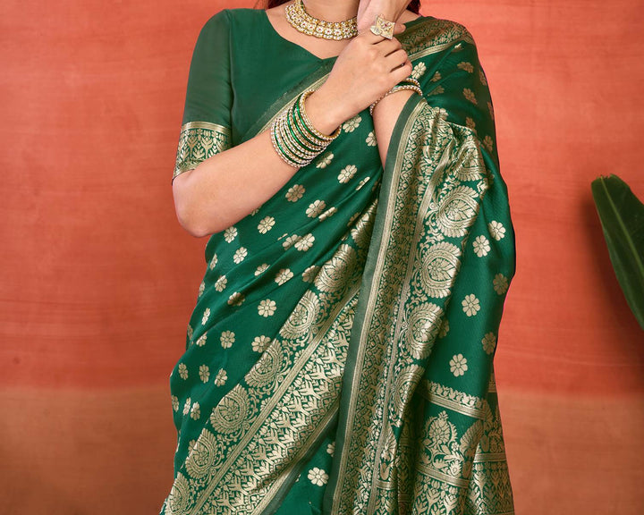 Three-quarter view of model in bottle green Banarasi silk saree showing gold zari daisy buttas and dense diamond jaal pallu drape