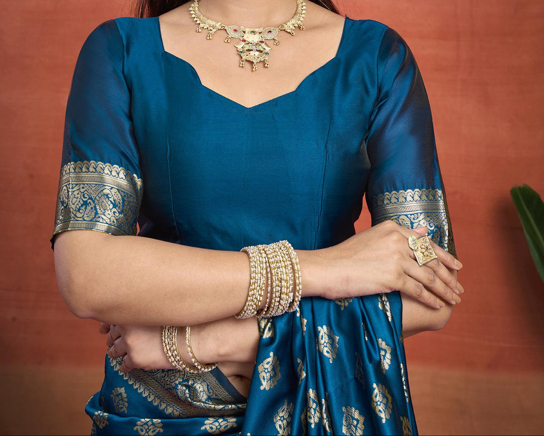 Close-up of peacock blue Banarasi silk saree pallu showing large oval medallions with dense gold zari floral jaal