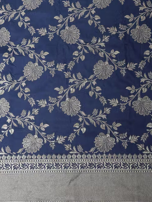 Close-up of navy blue Banarasi silk fabric showing silver zari floral jaal weave