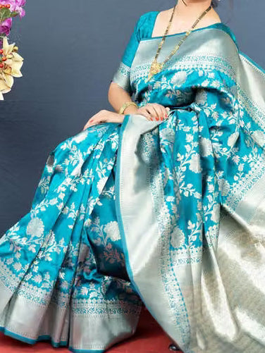Close-up portrait of model wearing teal Banarasi silk saree and matching blouse